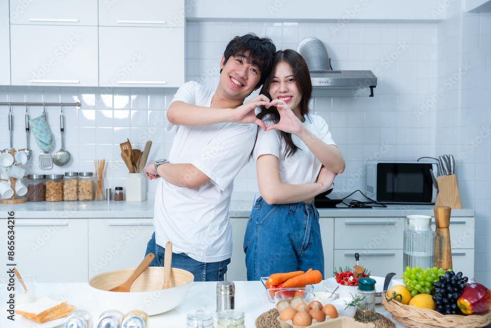 Happy portrait of loving young asian of having fun standing a cheerful heart shaped hands preparing food and enjoy cook cooking bread while standing on a kitchen Condo life or home Happy portrait of loving young asian of having fun standing a cheerful heart shaped hands preparing food and enjoy cook cooking bread while standing on a kitchen Condo life or home