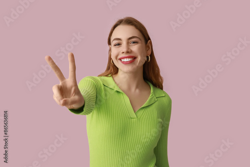Wallpaper Mural Pretty young woman showing peace gesture on pink background Torontodigital.ca