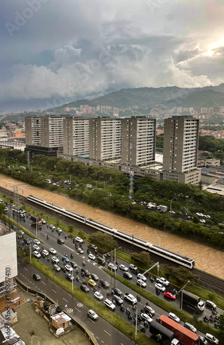 Aerial view of the Medellin Metro, entering the industrial station on a cloudy afternoon next to the river. photo