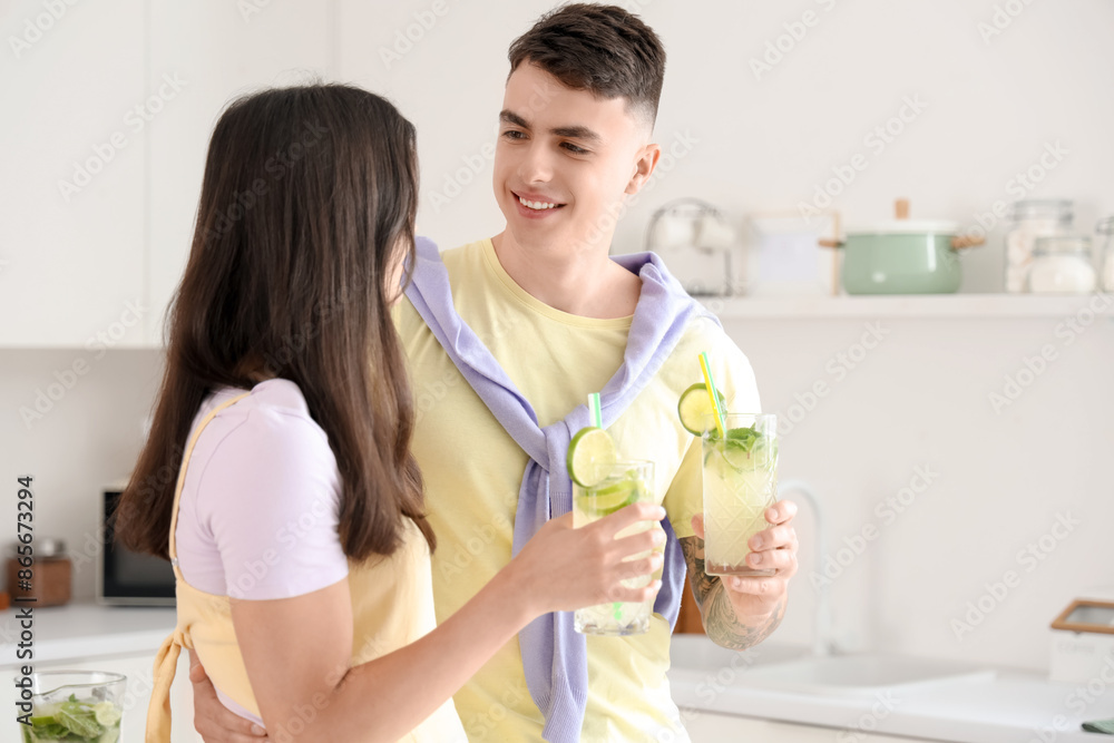 Happy young couple with glasses of mojito in kitchen at home Happy young couple with glasses of mojito in kitchen at home