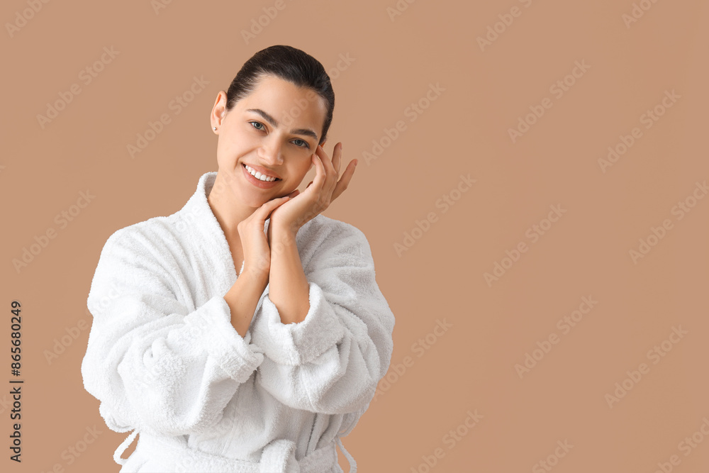 Beautiful young happy woman in bathrobe on beige background Beautiful young happy woman in bathrobe on beige background