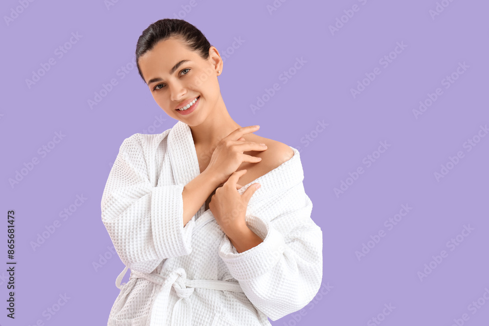 Beautiful young happy woman in bathrobe on purple background Beautiful young happy woman in bathrobe on purple background