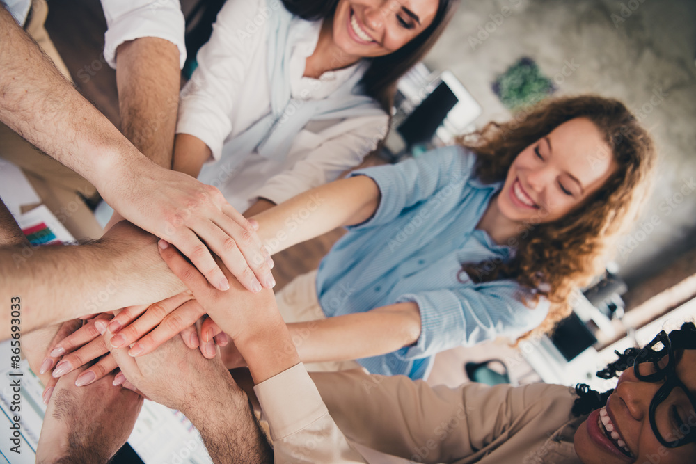 Obraz premium Cropped portrait of group professional corporate workers pile stack hand shake loft interior business center indoors