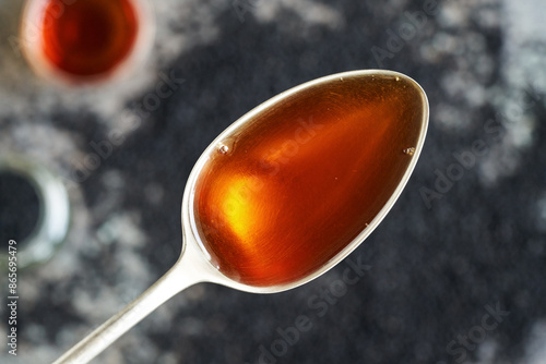 Black cumin or Nigella sativa seed oil on a metal spoon photo