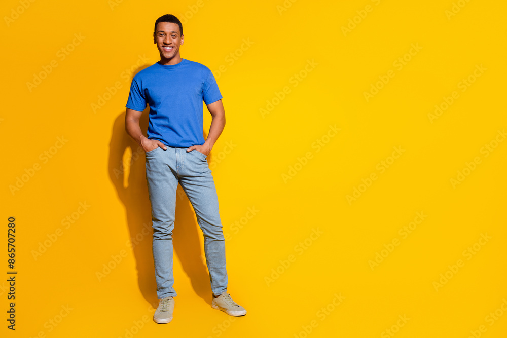 Fototapeta premium Full body photo of attractive young man posing model hands pockets dressed stylish blue clothes isolated on yellow color background