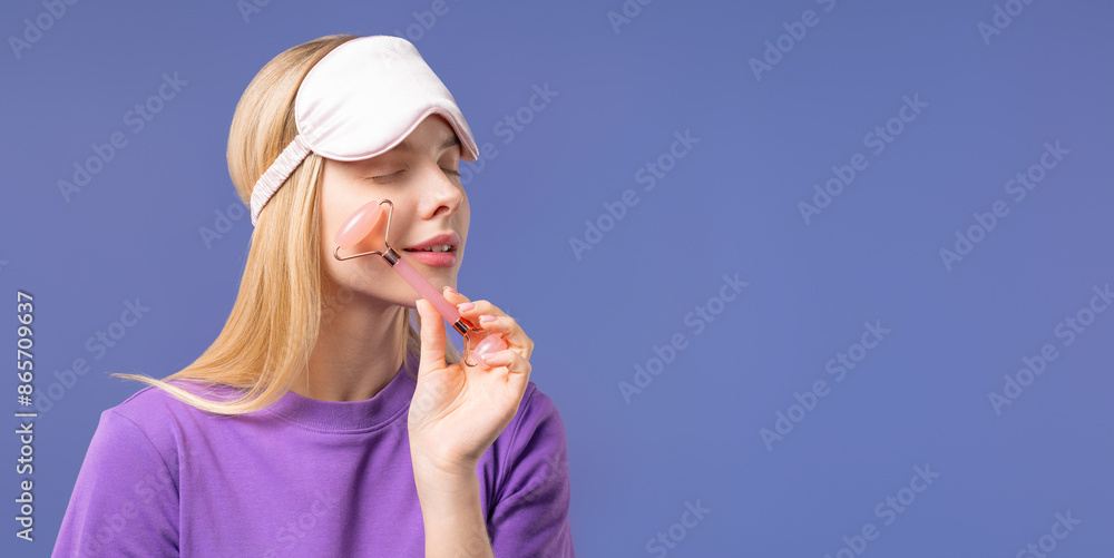 Young woman with rose quartz stone roller on Violet background. Facial self care Young woman with rose quartz stone roller on Violet background. Facial self care