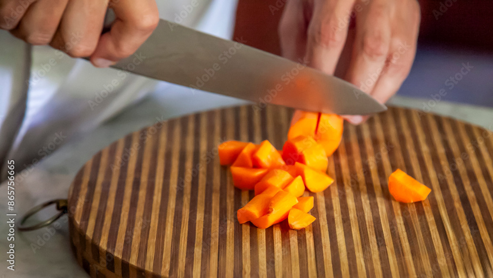 Man's Hands Cutting Fresh Carrots on Wooden Board Man's Hands Cutting Fresh Carrots on Wooden Board
