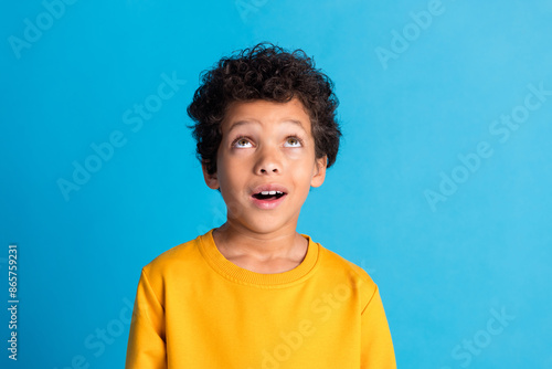 Obraz na plátne Portrait of cute small schoolkid look up empty space wear pullover isolated on b