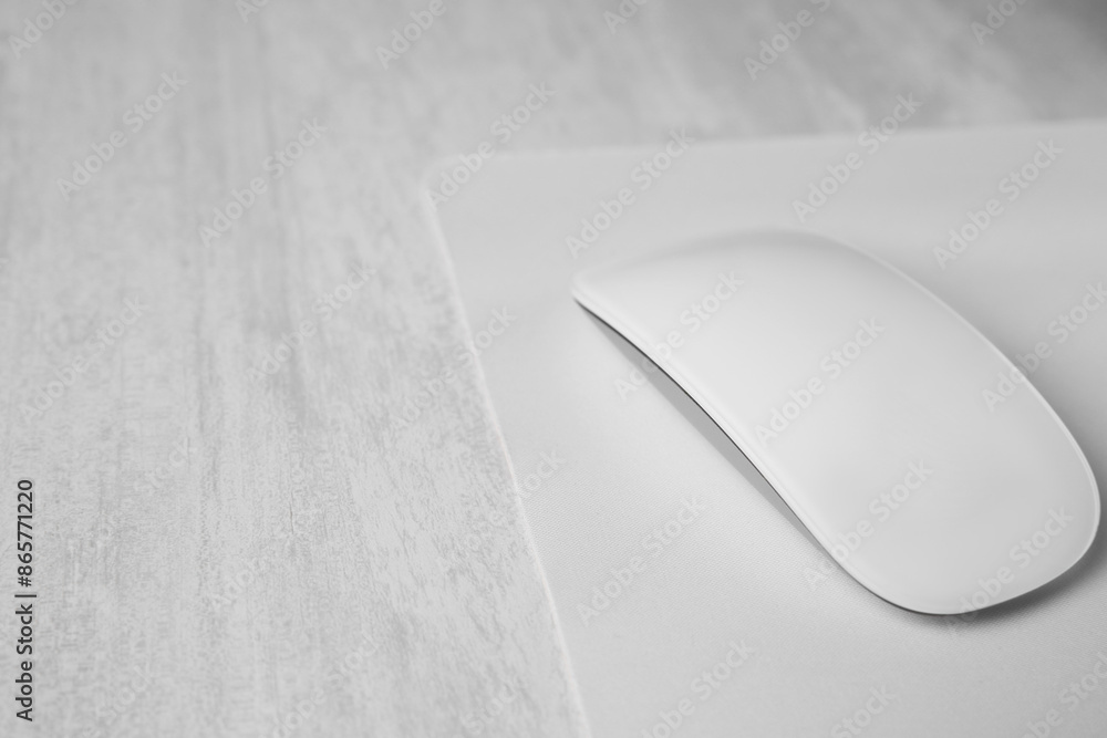 One wireless mouse with mousepad on grey wooden table, closeup. Space for text One wireless mouse with mousepad on grey wooden table, closeup. Space for text