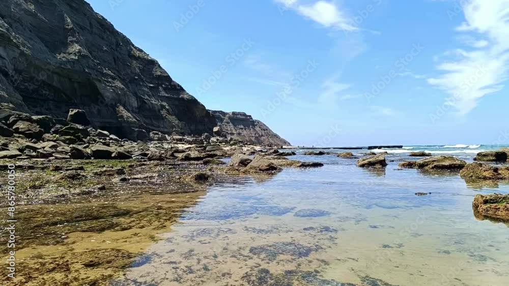 Slow movement of water at high tide with waves breaking on the horizon and next to the cliff on Foz do Sizandro beach, PORTUGAL Slow movement of water at high tide with waves breaking on the horizon and next to the cliff on Foz do Sizandro beach, PORTUGAL
