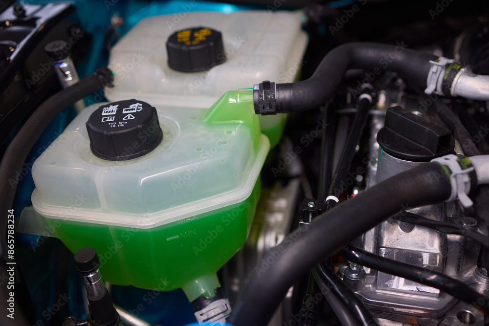 © Евгений Вершинин - Get a closer look at the coolant reservoir of a car, situated in the engine compartment