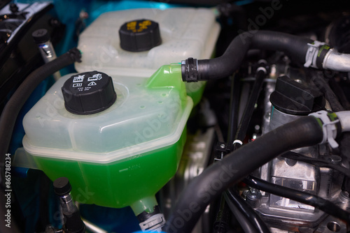 Photography Get a closer look at the coolant reservoir of a car, situated in the engine comp