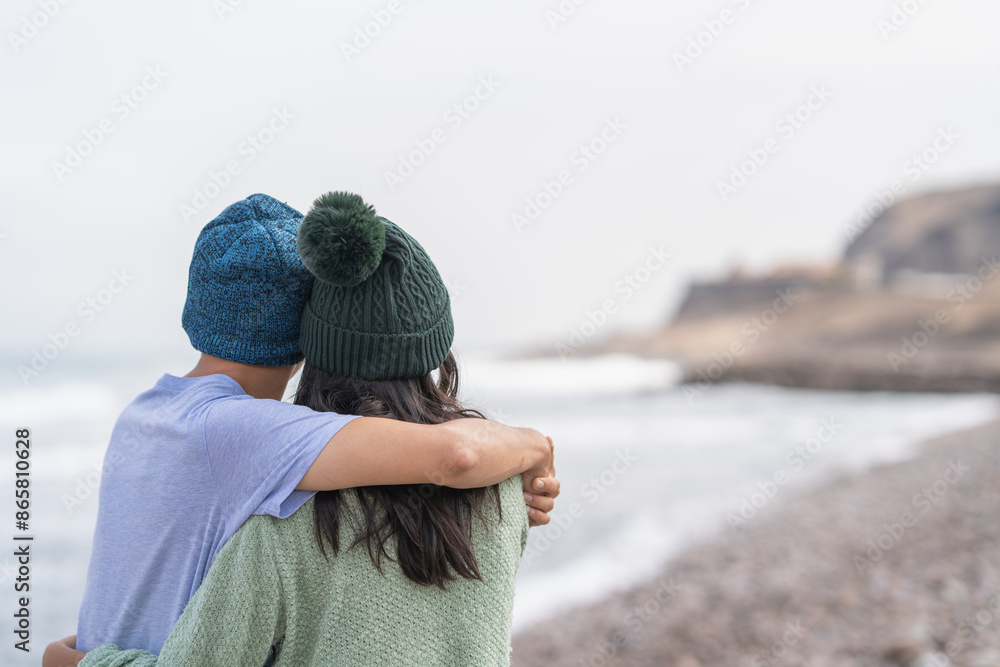 Young couple embracing contemplating the ocean Young couple embracing contemplating the ocean