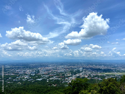 REAL PHOTOS Image of white clouds on a clear day floating above a beautiful city.
