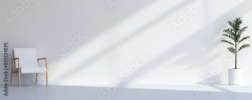 Minimalist interior with white armchair and a potted plant against a white wall. Sunlight streaming in, creating a calm and serene atmosphere.