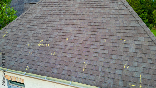 Roof with hail damage and marking from hail insurance inspection photo