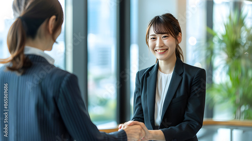 Two women in business suits shaking hands © alfi
