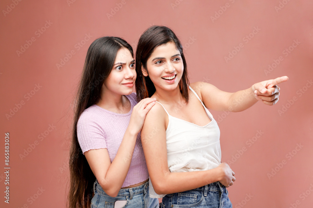 Two Nice Mature Women Are Smiling And Pointing Their Fingers To The Left Two Nice Mature Women Are Smiling And Pointing Their Fingers To The Left