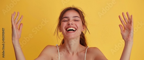 Woman With Long Brown Hair Laughing in Front of Yellow Background