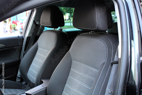 Front gray fabric drivers and passenger seat. Passenger seat side bolster inside of a car. Clean front modern car seats. 