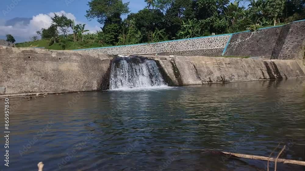 View of a beautiful artificial waterfall on a river View of a beautiful artificial waterfall on a river