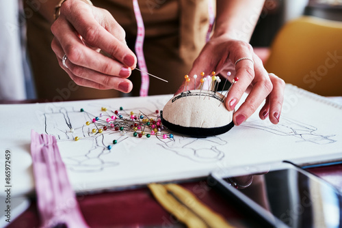 Hands, fashion designer and pincushion for crafting, fabric and layers in atelier or clothing business. Sewist, dressmaker and ballhead pins for basting, designs and sewing as tailor in workshop photo