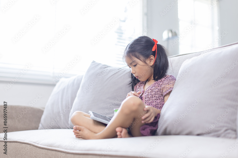 Little girl using tablet computer and have Snacks at home Little girl using tablet computer and have Snacks at home