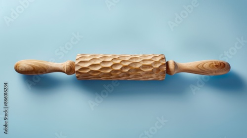 A rolling pin with a textured surface, against a light blue background.