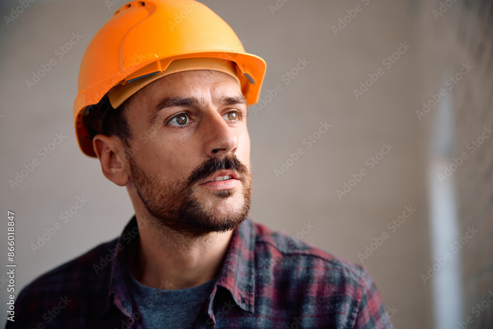 Portrait of manual worker at construction site looking away. Portrait of manual worker at construction site looking away.