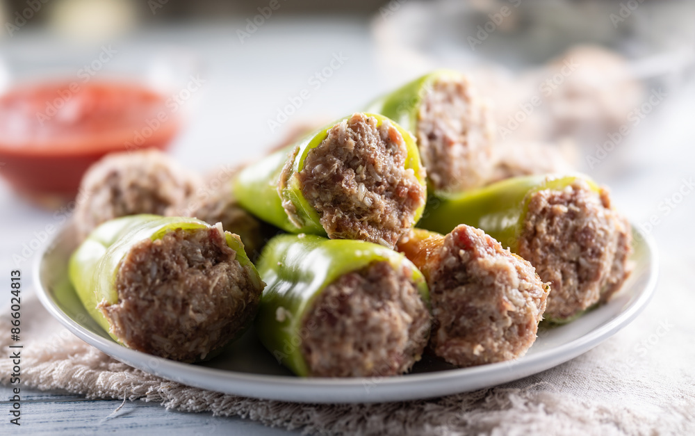 Stuffed green peppers on a plate ready for cooking or baking. Stuffed green peppers on a plate ready for cooking or baking.