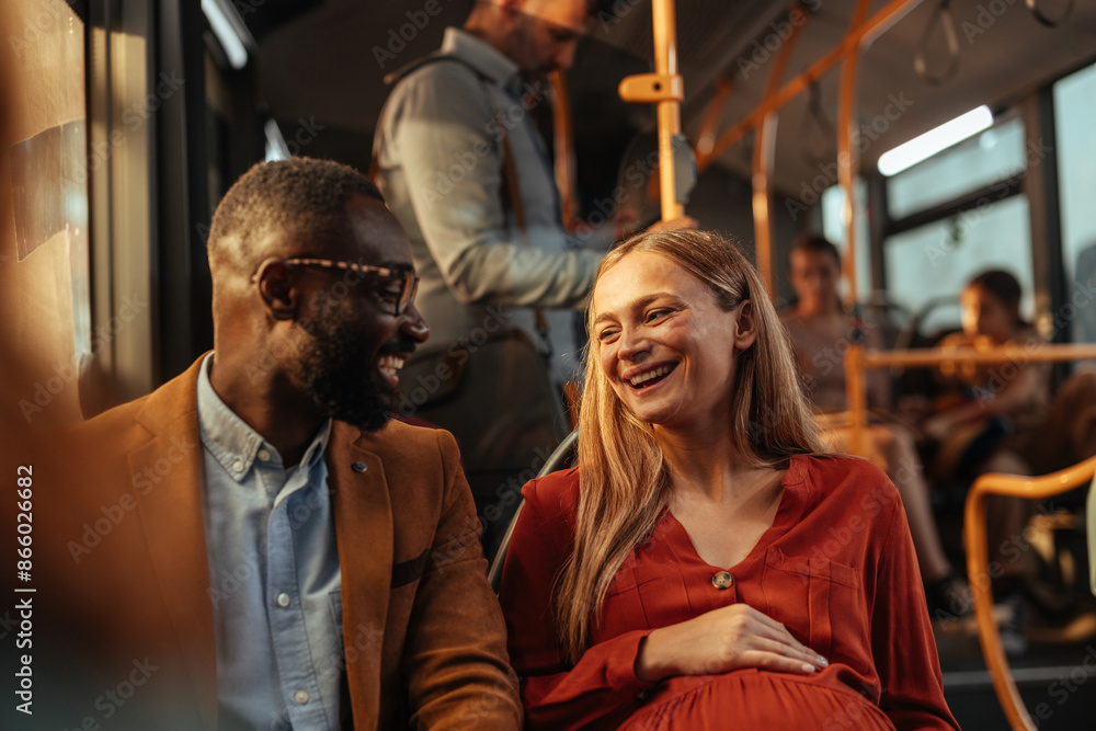 Pregnant woman and a man laughing on a bus Pregnant woman and a man laughing on a bus