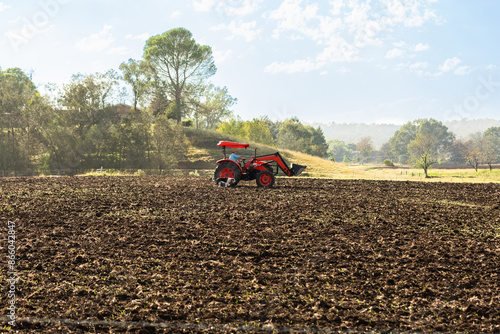 Loader tractor in tilled farm paddock photo