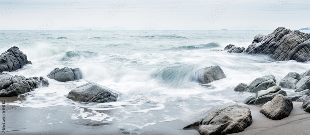 Seaside scene with gray rocks amidst the sea and white foamy waves along the shore creating a tranquil ambiance for a copy space image. Seaside scene with gray rocks amidst the sea and white foamy waves along the shore creating a tranquil ambiance for a copy space image.