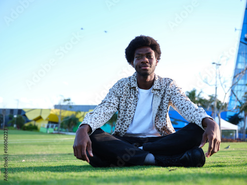 Man sitting cross-legged in a park photo