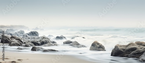 Wallpaper Mural Seaside scene with gray rocks amidst the sea and white foamy waves along the shore creating a tranquil ambiance for a copy space image. Torontodigital.ca