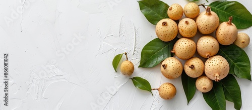 Top view of a fresh longan fruit with leaves on a white background, creating a flat lay composition with copy space image. photo