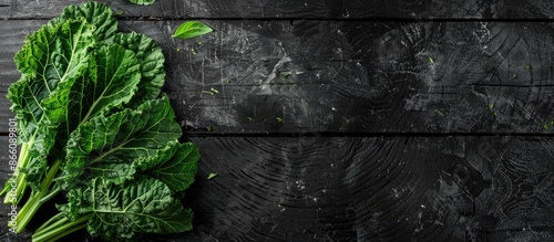 Copy space image featuring Chinese kale on a wooden black background. photo
