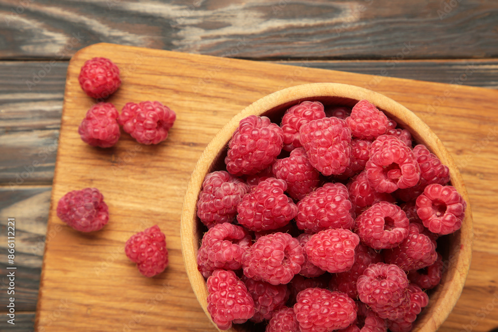 Raspberries in wooden bowl on brown background Raspberries in wooden bowl on brown background