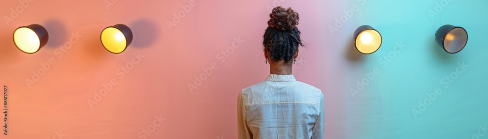 Woman with bun hairstyle standing against a vibrant, two-tone wall with round lights, creating a modern and artistic vibe. Woman with bun hairstyle standing against a vibrant, two-tone wall with round lights, creating a modern and artistic vibe.