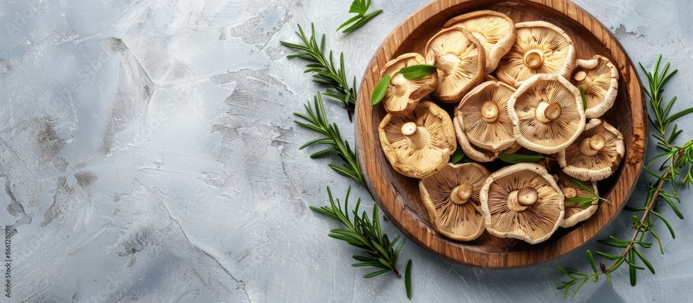 Dried shiitake mushrooms arranged on a wooden plate with herbs on a table background, creating a food and health concept with copy space image. Dried shiitake mushrooms arranged on a wooden plate with herbs on a table background, creating a food and health concept with copy space image.