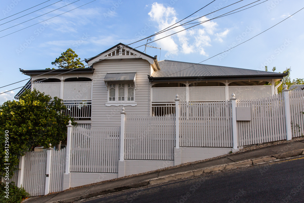 old grey timber queenslander house on a steep sloped street old grey timber queenslander house on a steep sloped street