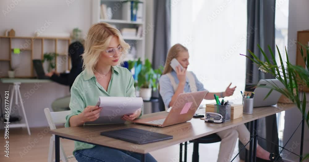 Young Corporate Employee Looking Through Documents Young Corporate Employee Looking Through Documents