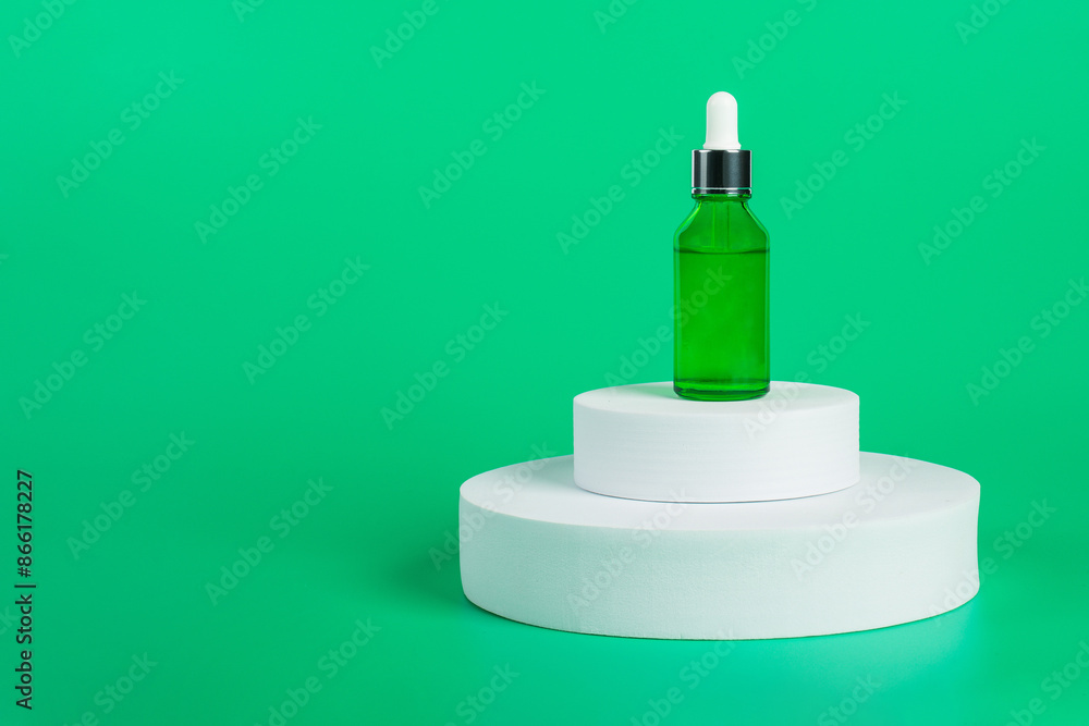 Green glass cosmetic bottle, Skin care or sunscreen cosmetic with stylish props on green background. Green glass cosmetic bottle, Skin care or sunscreen cosmetic with stylish props on green background.