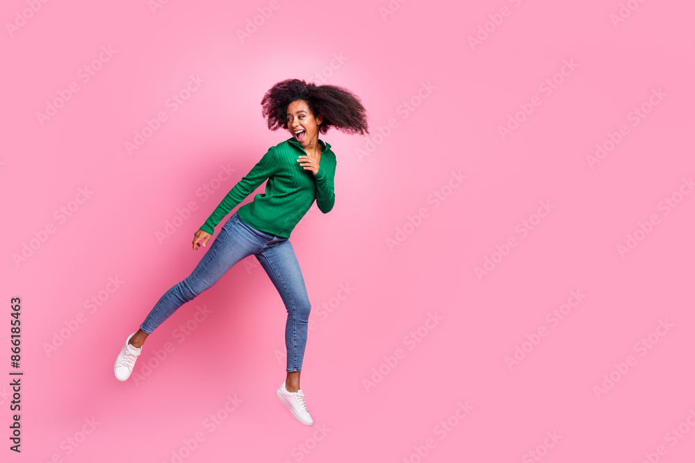 Full size photo of pretty young girl jumping look empty space wear trendy green outfit isolated on pink color background Full size photo of pretty young girl jumping look empty space wear trendy green outfit isolated on pink color background