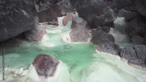 Brook flow with hot sulfur-containing water in the Sorikmarapi volcano area, North Sumatra, Indonesia. photo