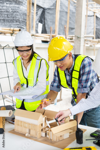 Engineer teams meeting working together wear worker helmets hardhat on construction site in city.