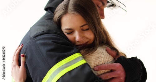 Close-up The fireman hugs the girl, who is happy that he came back unharmed. Footage of a firefighter with a girl on a white background in the studio photo