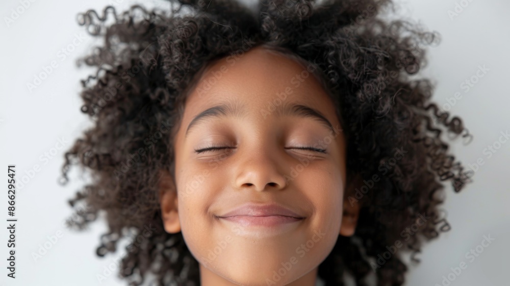 Closeup of a smiling black child lying on his back with eyes closed. Concept of peaceful, happy, and relaxed childhood. Closeup of a smiling black child lying on his back with eyes closed. Concept of peaceful, happy, and relaxed childhood.