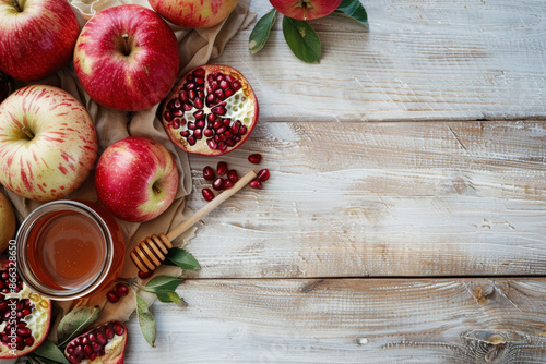 Honey, apples and pomegranates are composing a still life on a rustic wooden table, celebrating the jewish new year photo