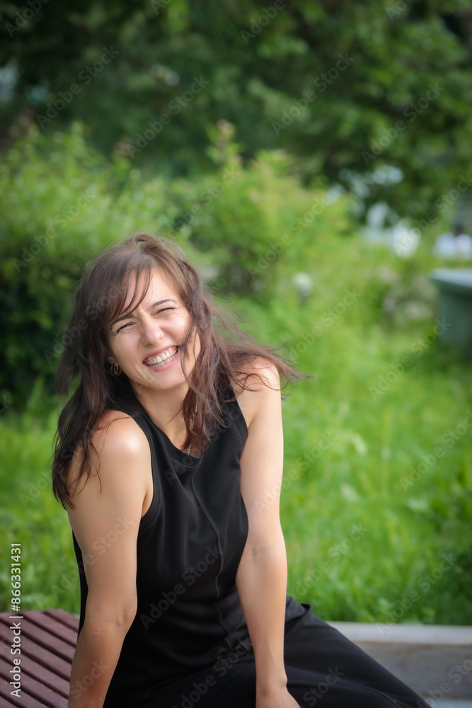 Happy girl laughing on a park bench Happy girl laughing on a park bench